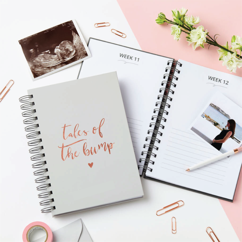 A pregnancy journal opened to the page of Week 11 and 12. There is also a picture of a pregnant mum and ultrasound scan of baby.